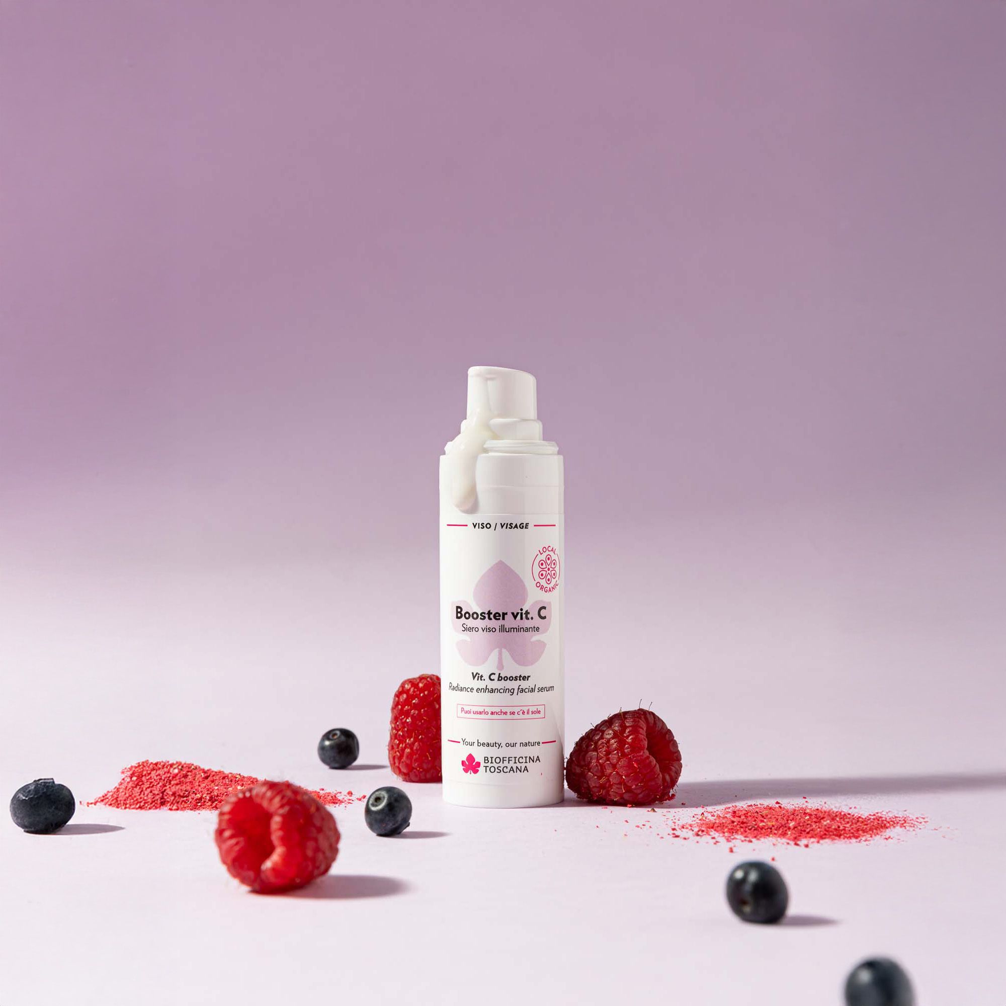 Flacone bianco con vaporizzatore, nome del prodotto e bacche. Polvere rosa e bacche su sfondo viola.