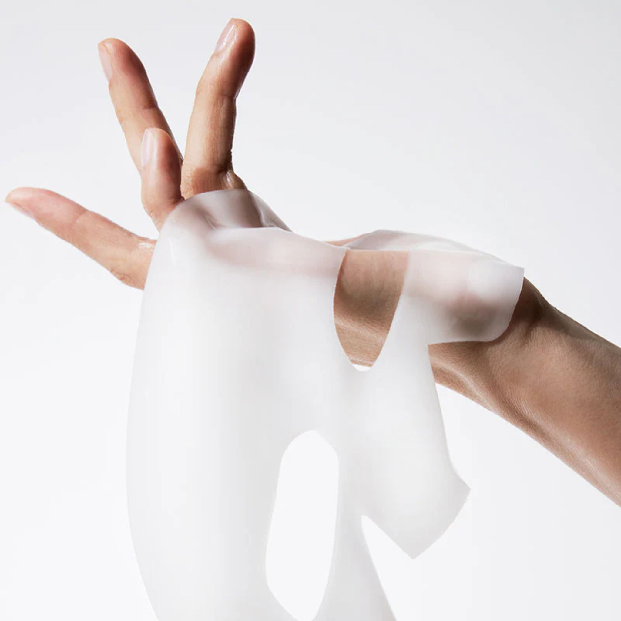 Mani che tengono una maschera facciale trasparente. La maschera ha aperture per occhi, naso e bocca. Realizzata in materiale morbido.