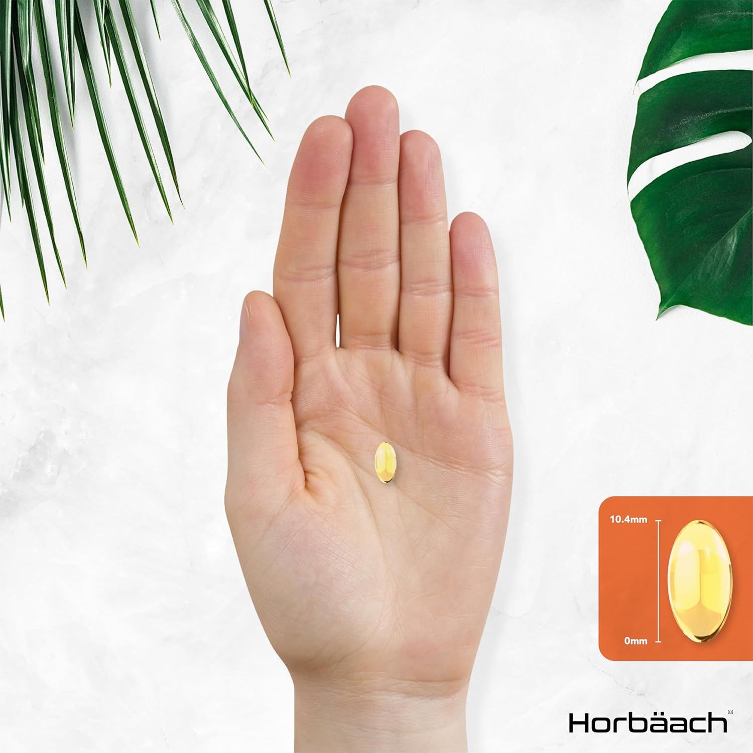 Mano con una capsula ovale gialla. Dimensioni: 10,4 mm x 6 mm.