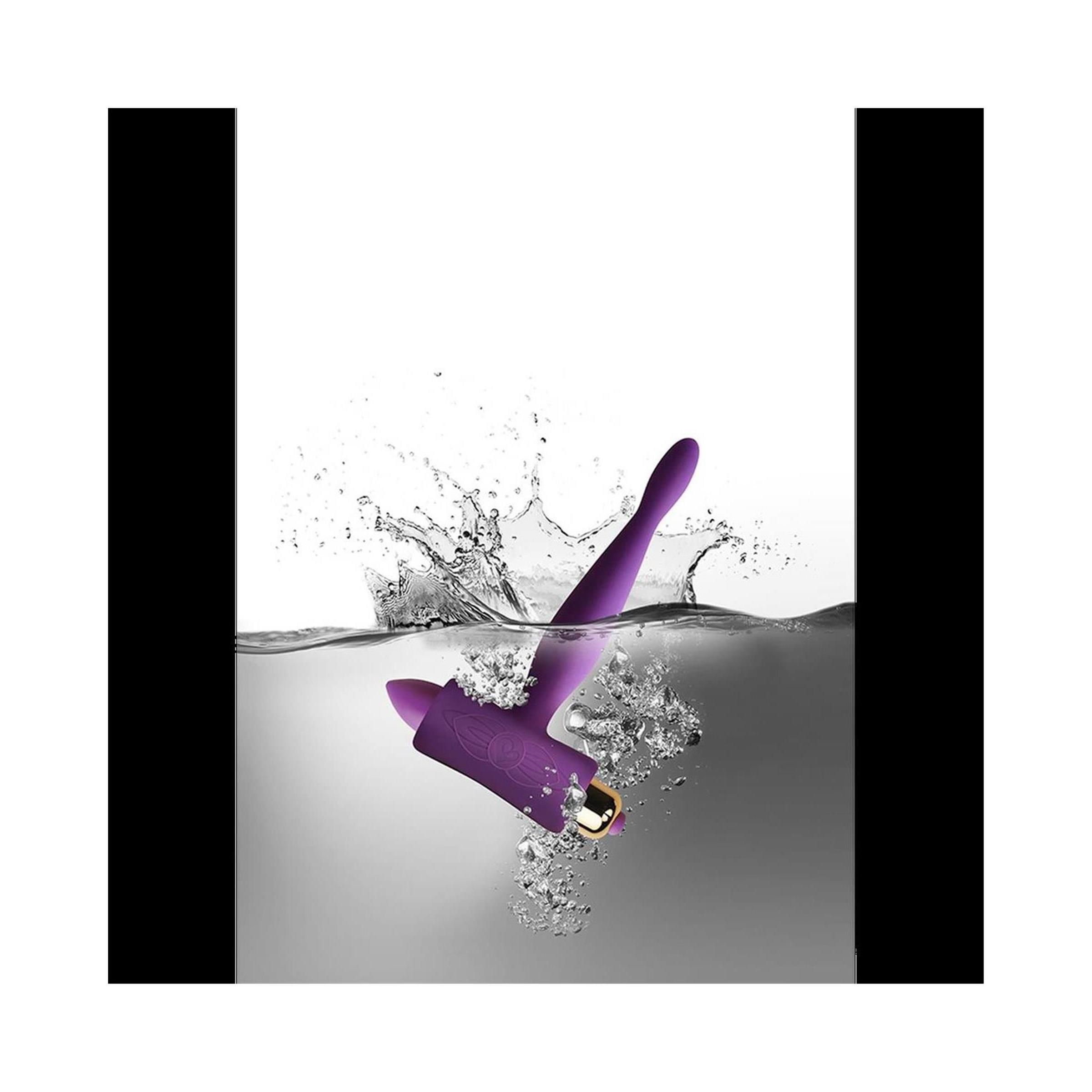 Prodotto lilla nell'acqua. A forma di T con punta arrotondata ed estremità cilindrica. Schizzi d'acqua.