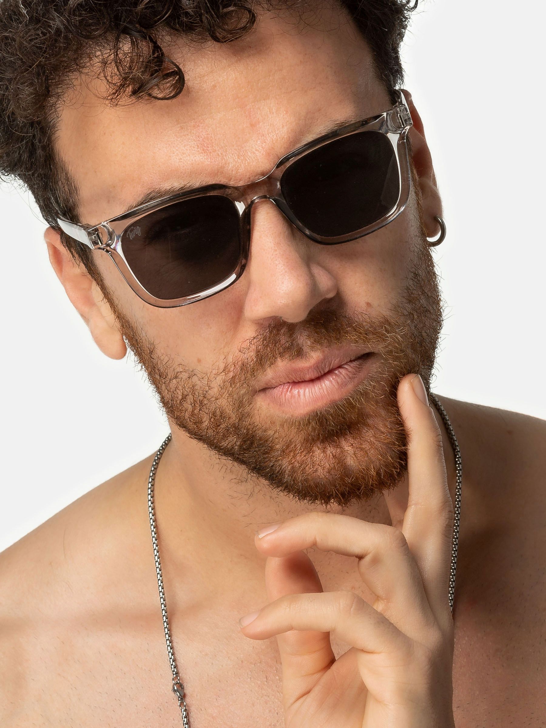 Uomo con occhiali da sole Twig. Montatura grigia, lenti rettangolari. Primo piano.