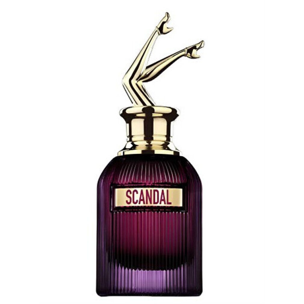 Flacone di profumo viola con tappo dorato a forma di gambe. Scritta "SCANDAL" su un rettangolo. Profumo.