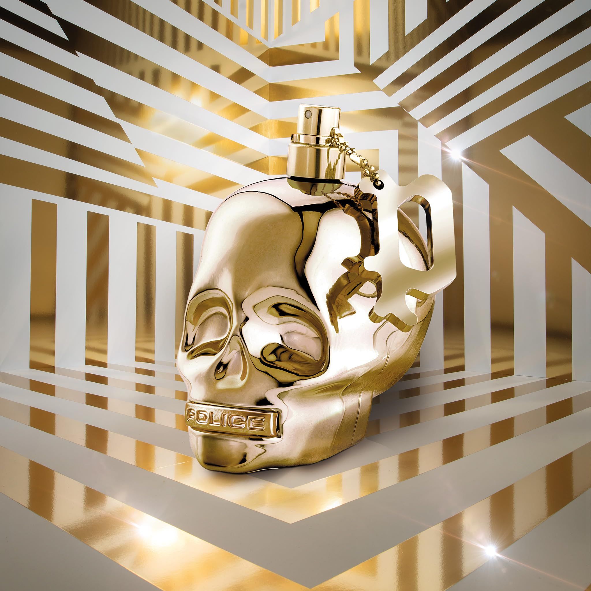 Flacone dorato a forma di teschio. Con vaporizzatore e ciondolo. Scritta: POLICE.