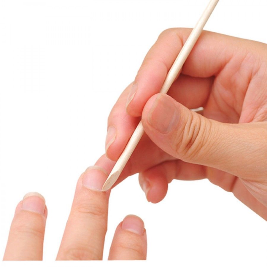 Bastoncino per manicure in uso. Un bastoncino viene utilizzato su un dito. Colore legno, punta arrotondata.