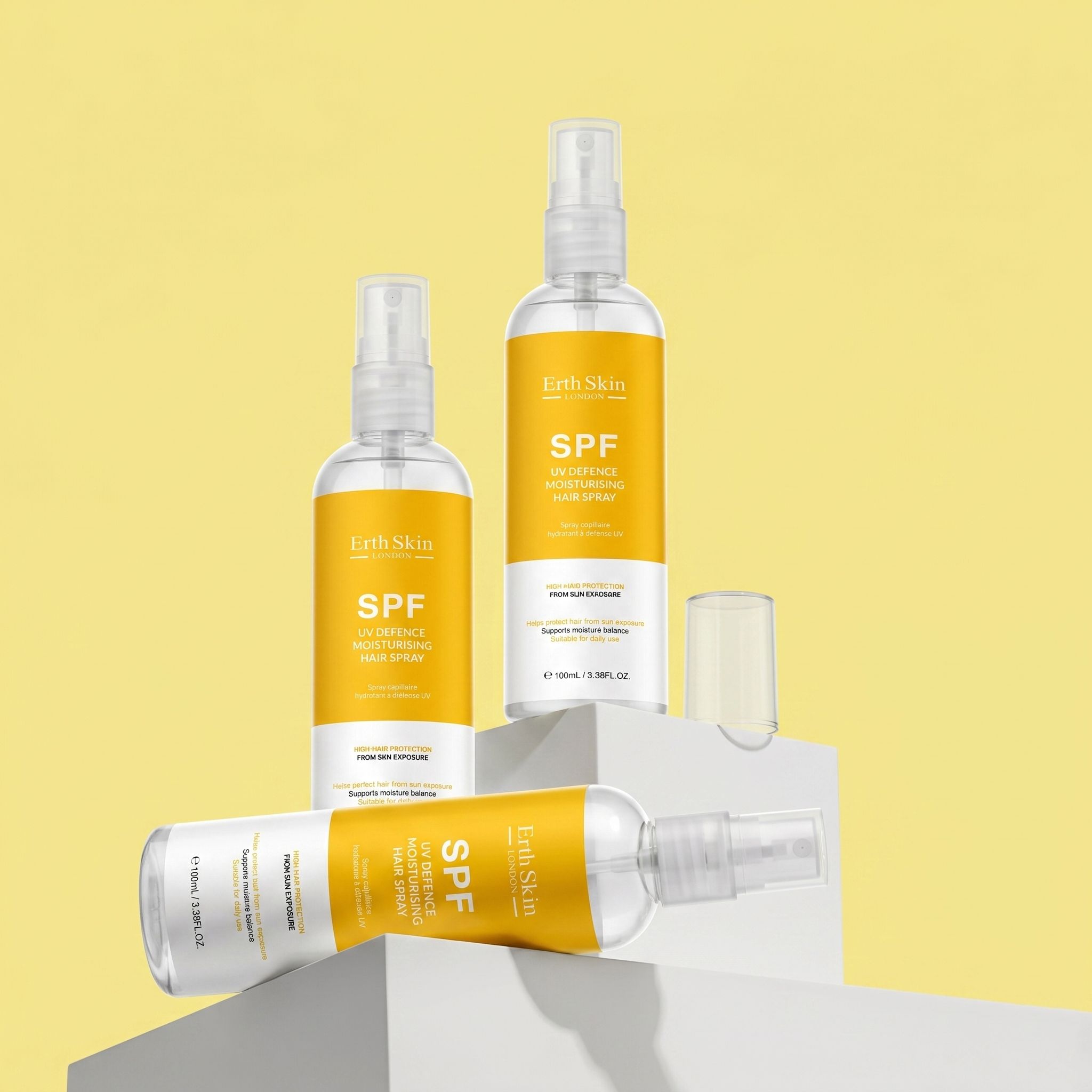 Diverse bottiglie di spray per capelli con etichette gialle. Scritta: SPF. Erogatori spray. ErthSkin London.