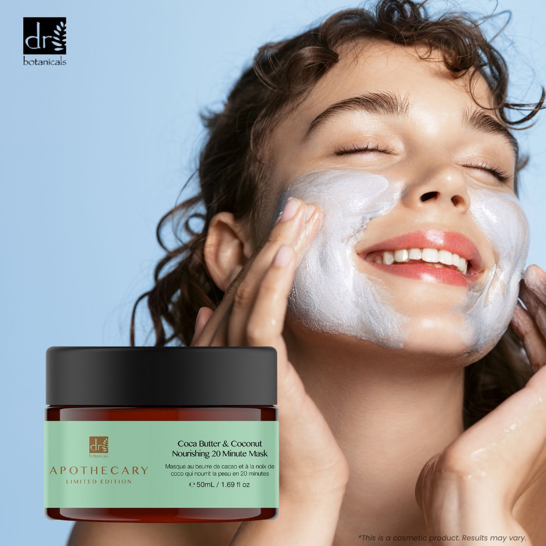 Donna che applica una maschera per il viso. Vaso con etichetta verde. Testo: Cocoa Butter & Coconut Nourishing 20 Minute Mask.