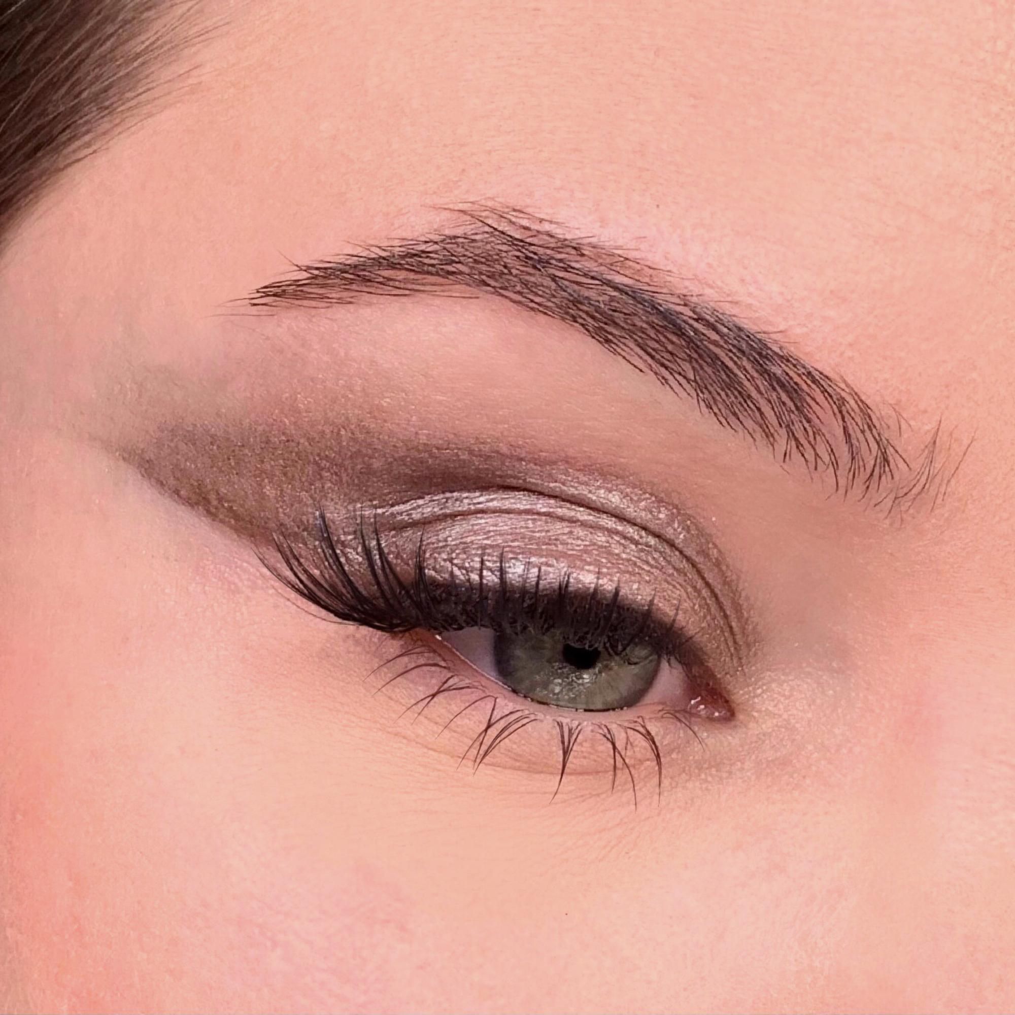 Primo piano di occhio truccato. Ombretto grigio. Sopracciglio e ciglia.