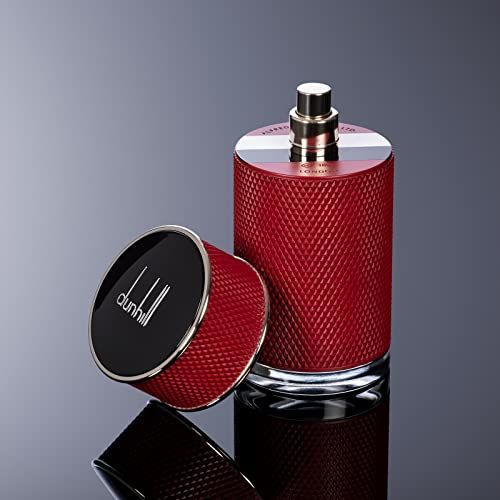 Flacone di profumo rosso con vaporizzatore argentato e tappo nero. Tappo accanto. Logo visibile.