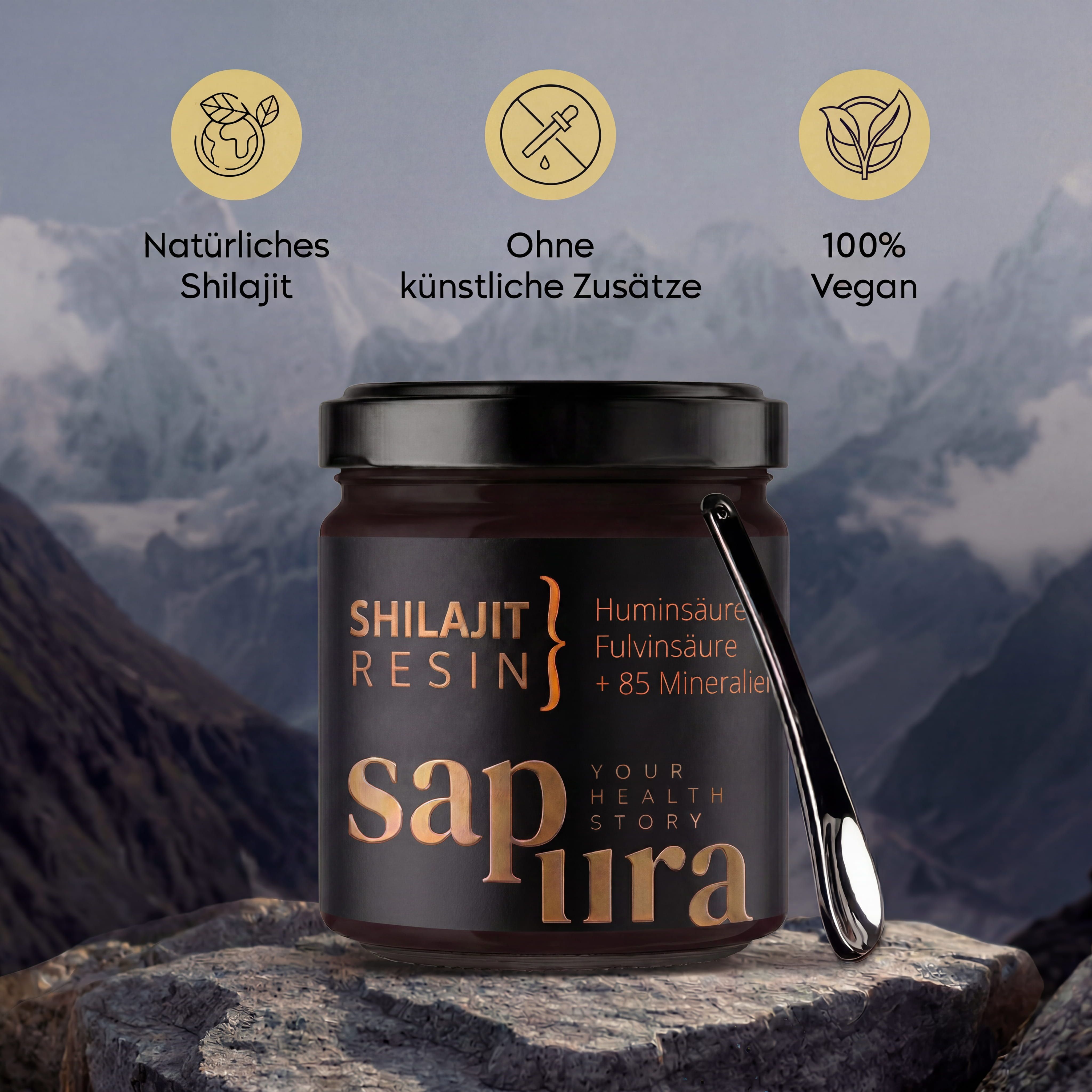 Shilajit Resin in barattolo con cucchiaino dosatore, davanti a paesaggio montano, con icone 'Naturale', 'Senza additivi', 'Vegano'.