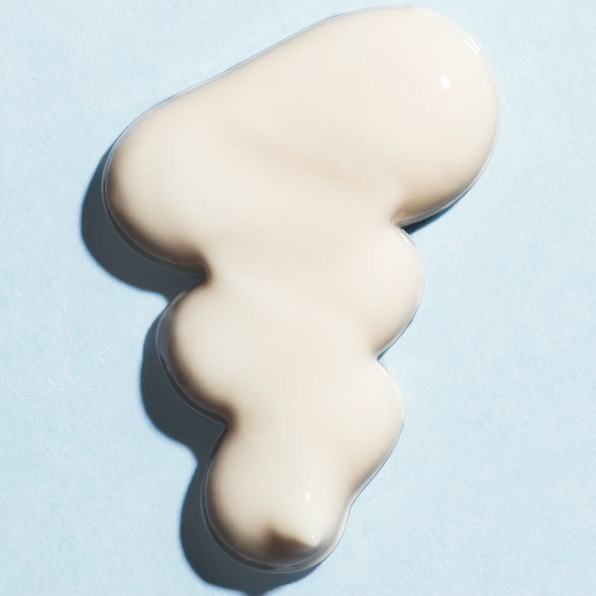 Macchia color crema chiaro su sfondo azzurro chiaro. Ombra.