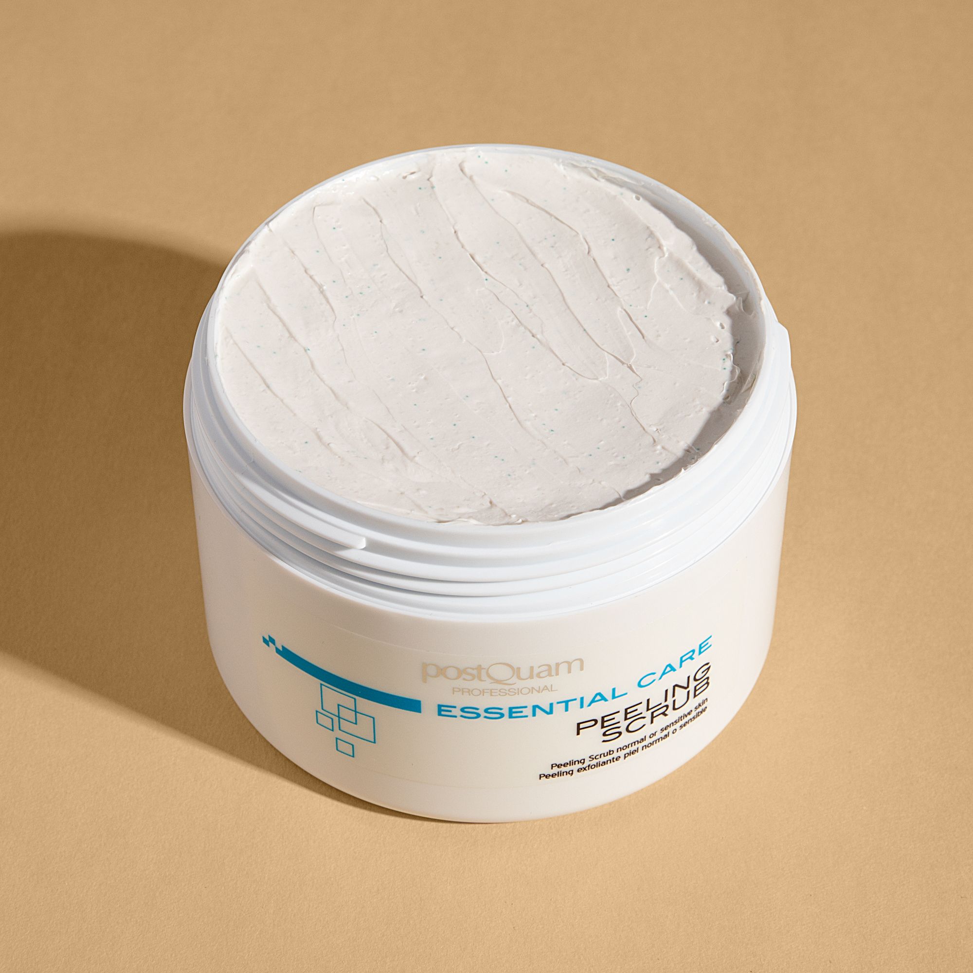 Vaso bianco aperto con sostanza cremosa. Scritta: Essential Care Peeling Scrub. Per pelli normali o sensibili.