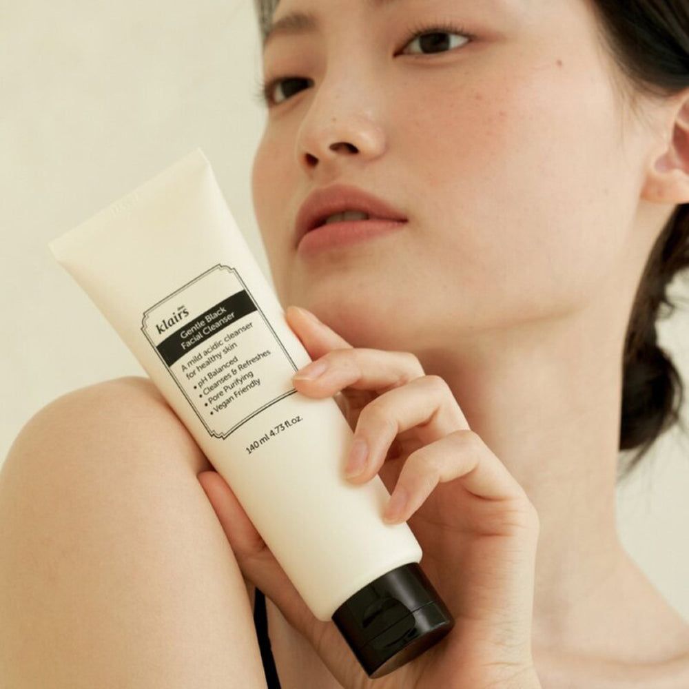 Persona che tiene un tubetto. Sul tubetto c'è scritto 'klairs Gentle Black Facial Cleanser'.