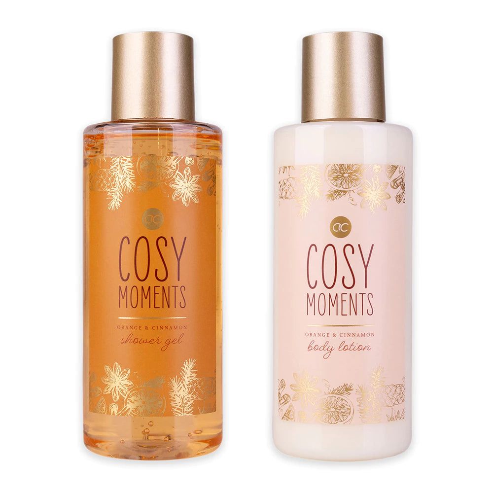 Due flaconi con tappi dorati. Scritta "Cosy Moments Orange & Cinnamon". Un gel doccia, una lozione.