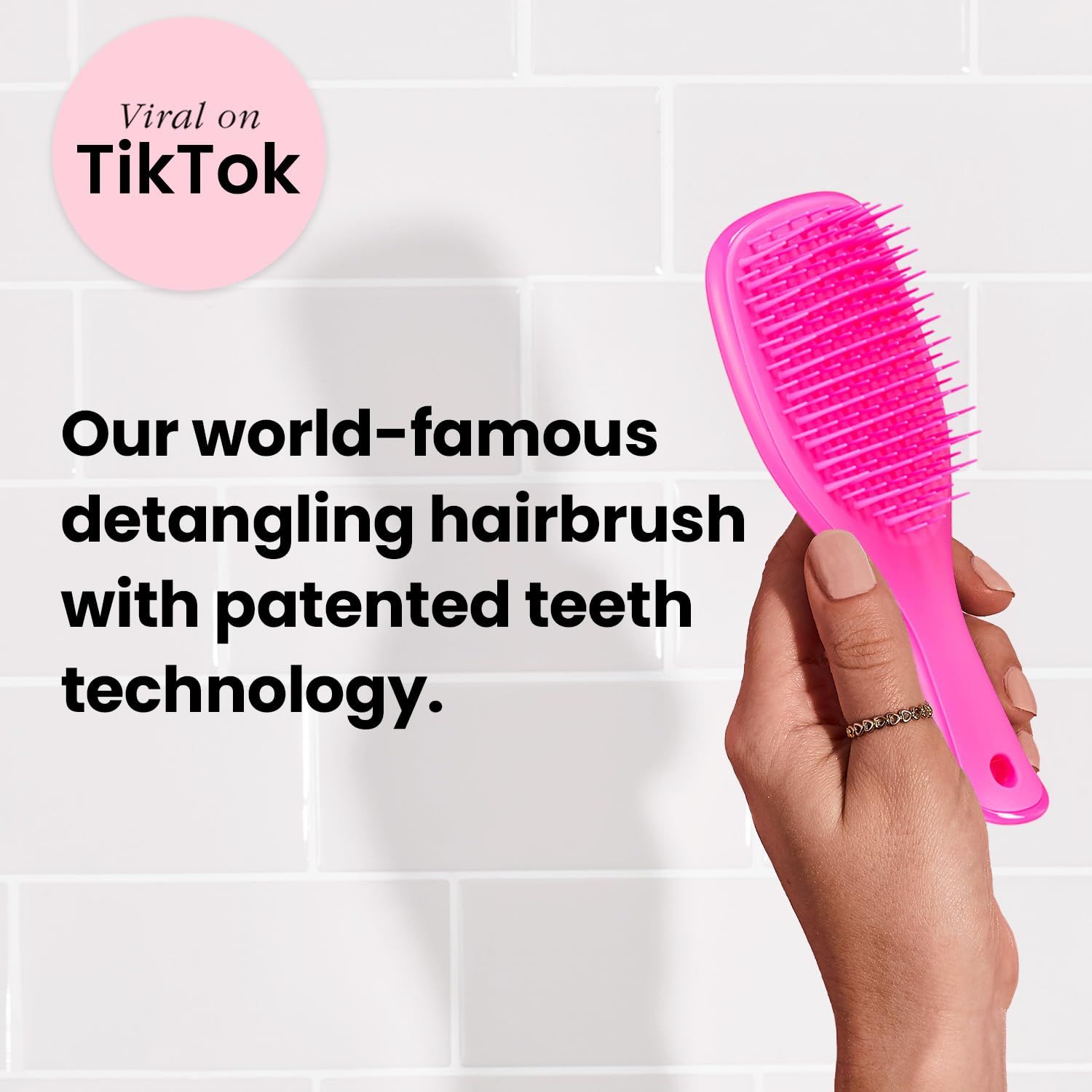 Spazzola per capelli rosa in mano. Testo: 'Our world-famous detangling hairbrush'.