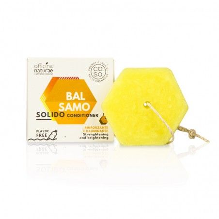 Balsamo solido esagonale giallo con cordino. Accanto, una scatola con nome prodotto e logo.