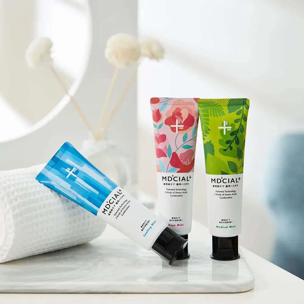 Tre tubi di dentifricio MD'CIAL+. Design diversi. Scritta Medical Mint, Cooling Mint, Rose Mint. Tappi neri.