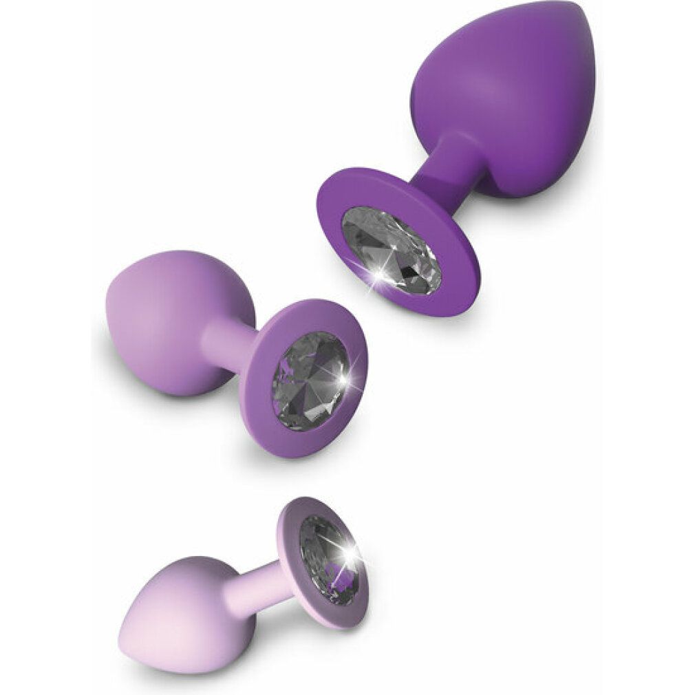 Tre plug anali viola con decorazioni in cristallo, diverse misure, primo piano.