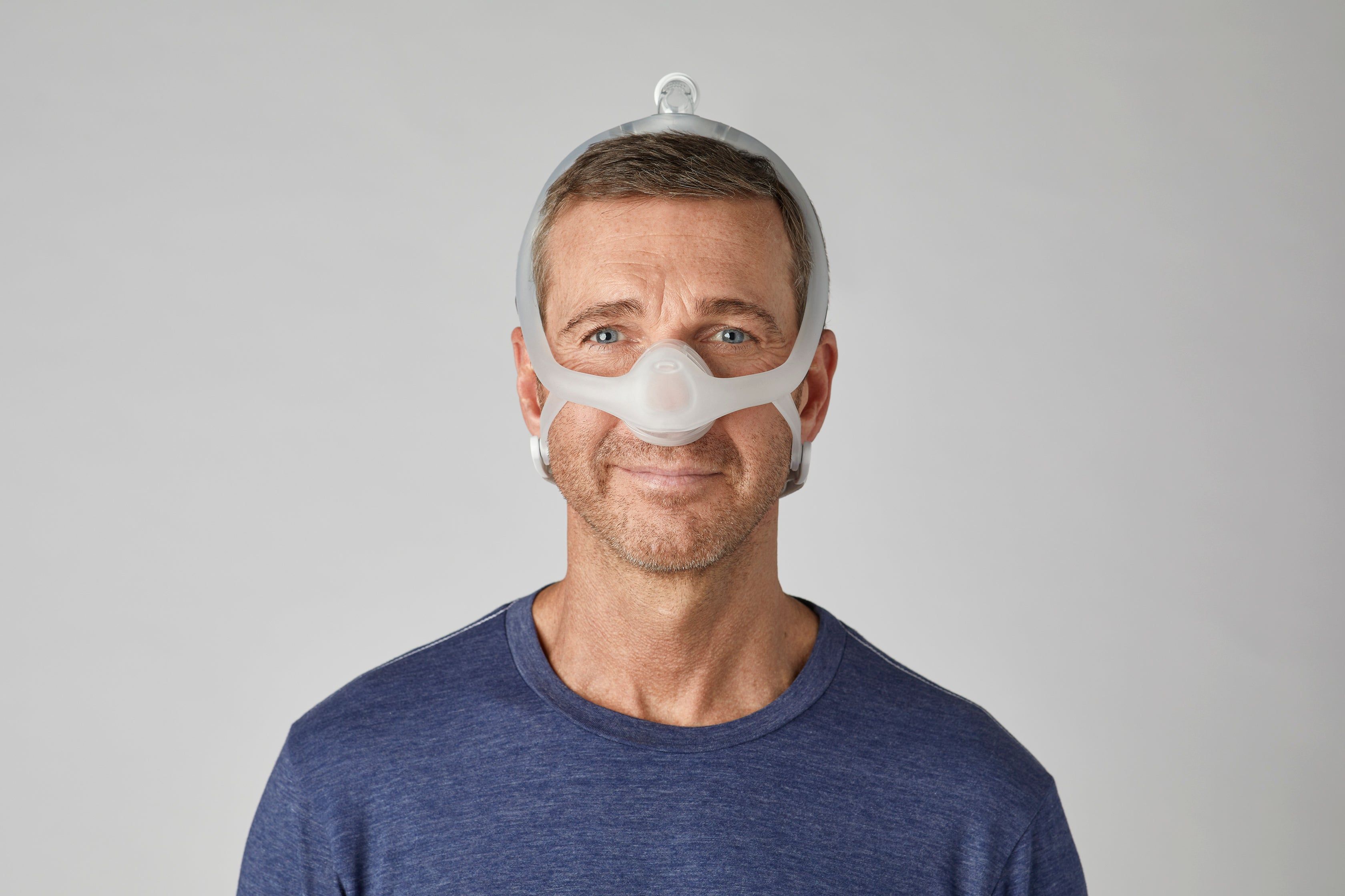 Un uomo indossa una maschera nasale bianca con fascia.