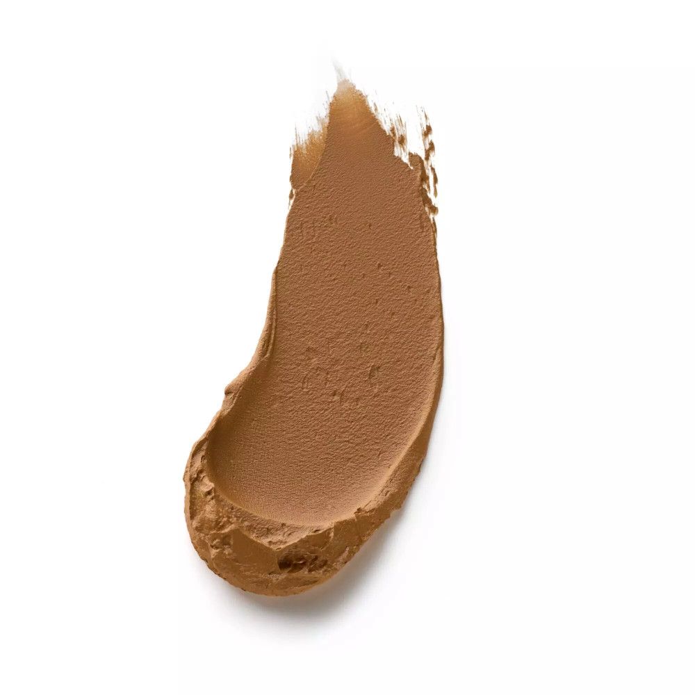 Una striscia di fondotinta marrone scuro su sfondo bianco. La consistenza è simile a una mousse.