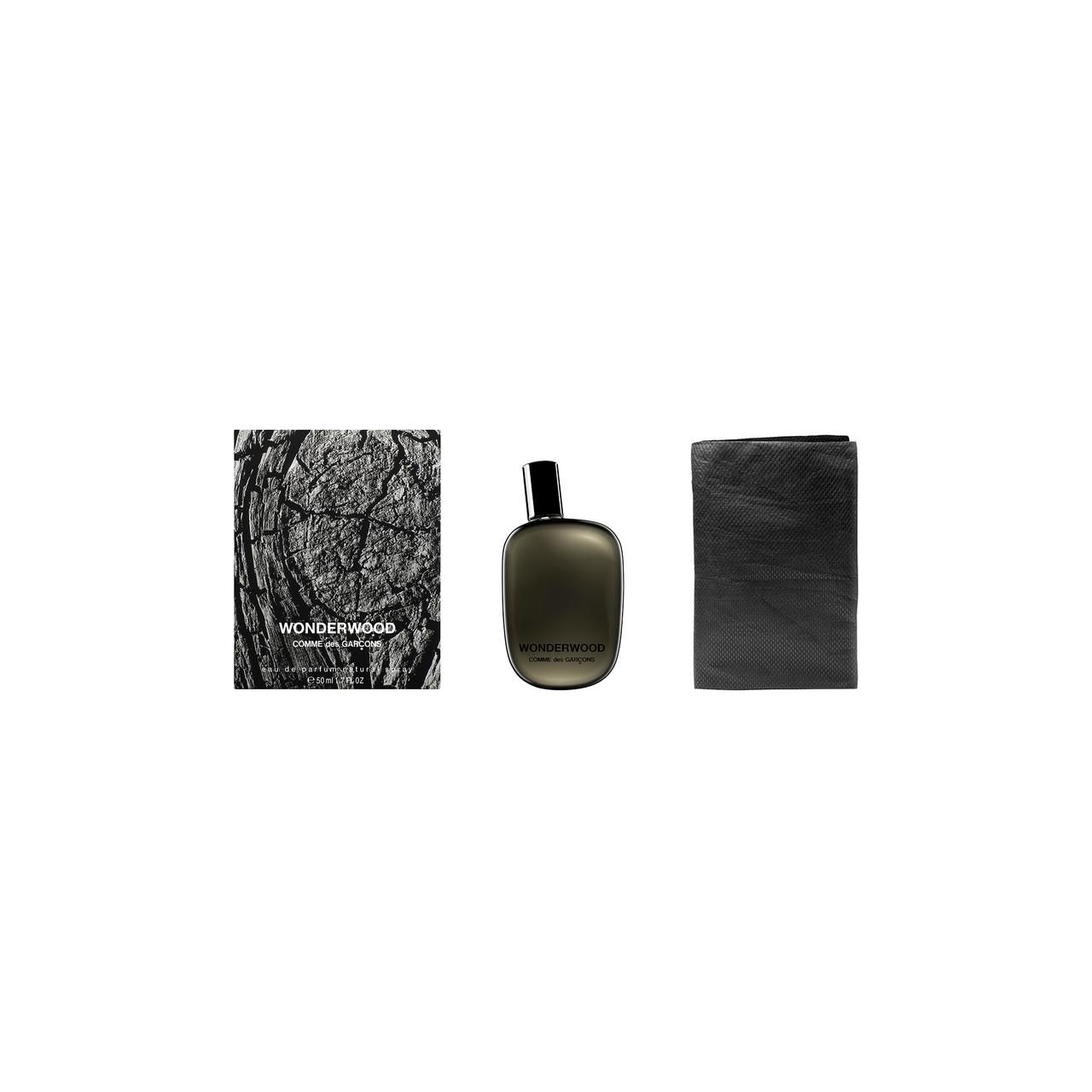 Flacone grigio scuro, scatola e tessuto. Scritta: Wonderwood, Comme des Garçons.