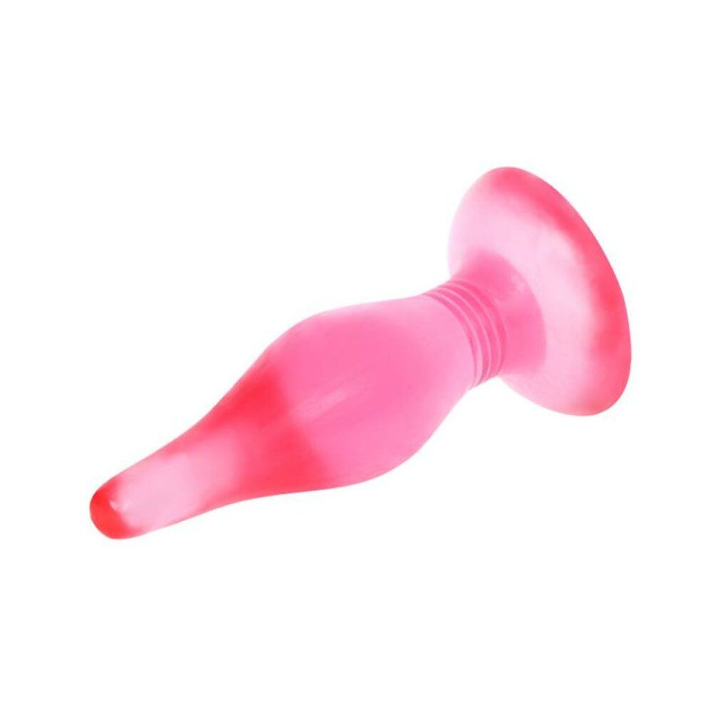 Plug anale rosa, sdraiato. Ampia base rotonda, raccordo scanalato allo stelo conico. Superficie liscia.