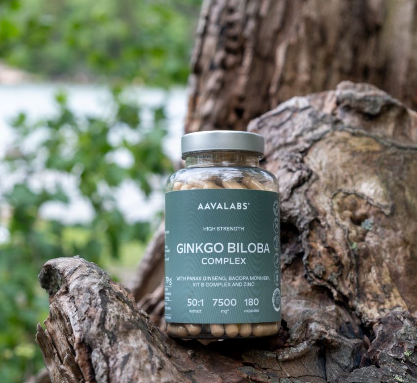 Flacone di Aavalabs Ginkgo Biloba Kapseln 7500mg su un tronco d'albero.