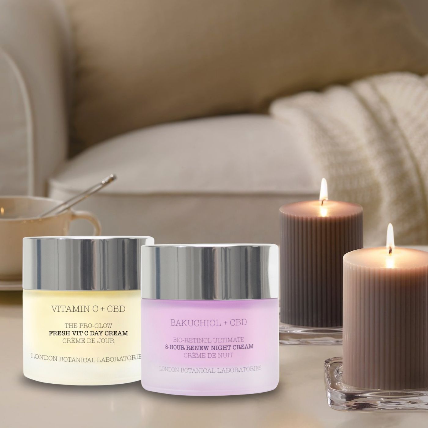 Due vasetti di crema giorno e notte accanto a candele accese. Scritta: Vitamin C + CBD, Fresh Vit C Day Cream, London Botanical Laboratories. Bakuchiol + CBD, 8-Hour Renew Night Cream.