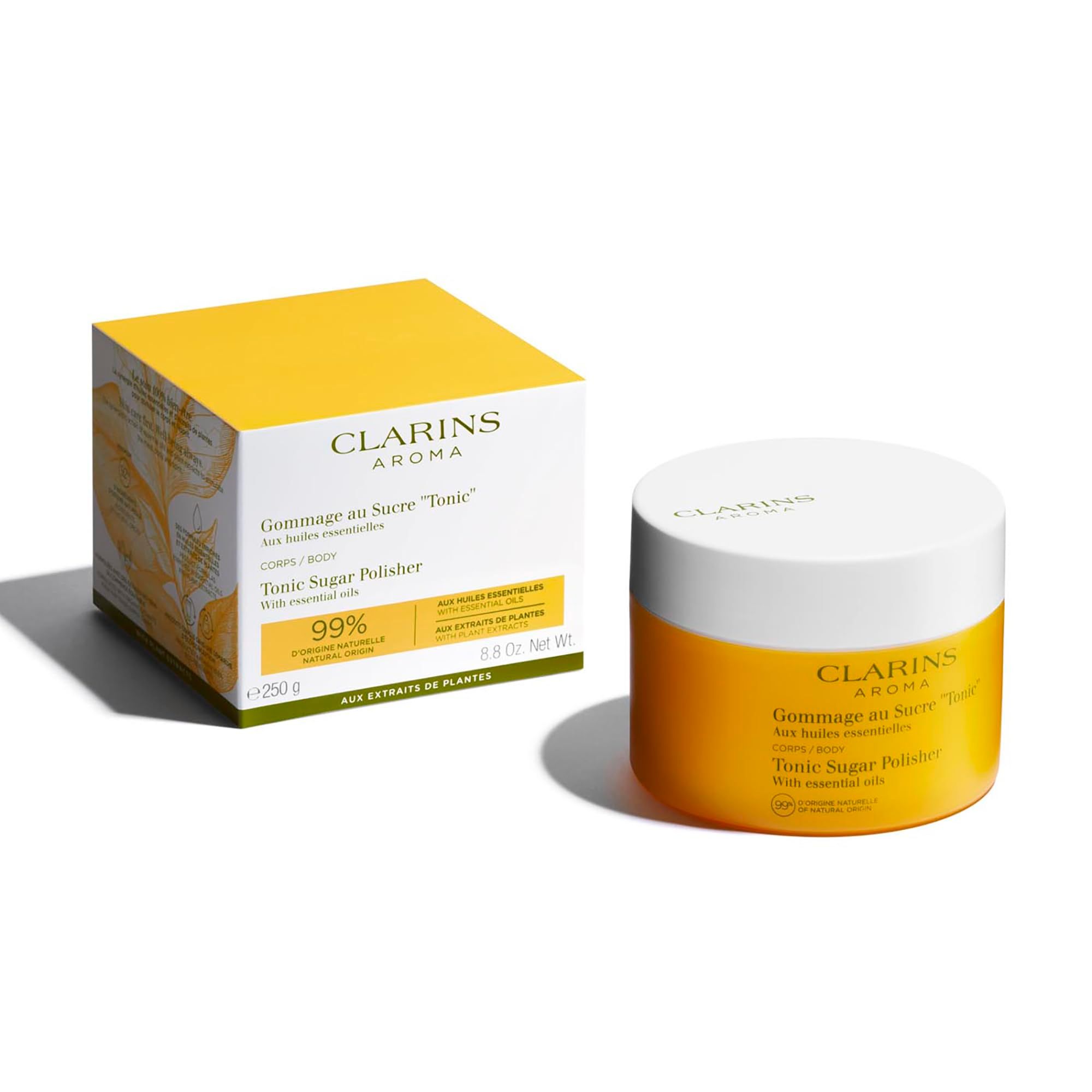 Vasetto e scatola gialli. Scritta: Clarins Aroma, Gommage au Sucre Tonic, Tonic Sugar Polisher. 99% origine naturale. 250 g.