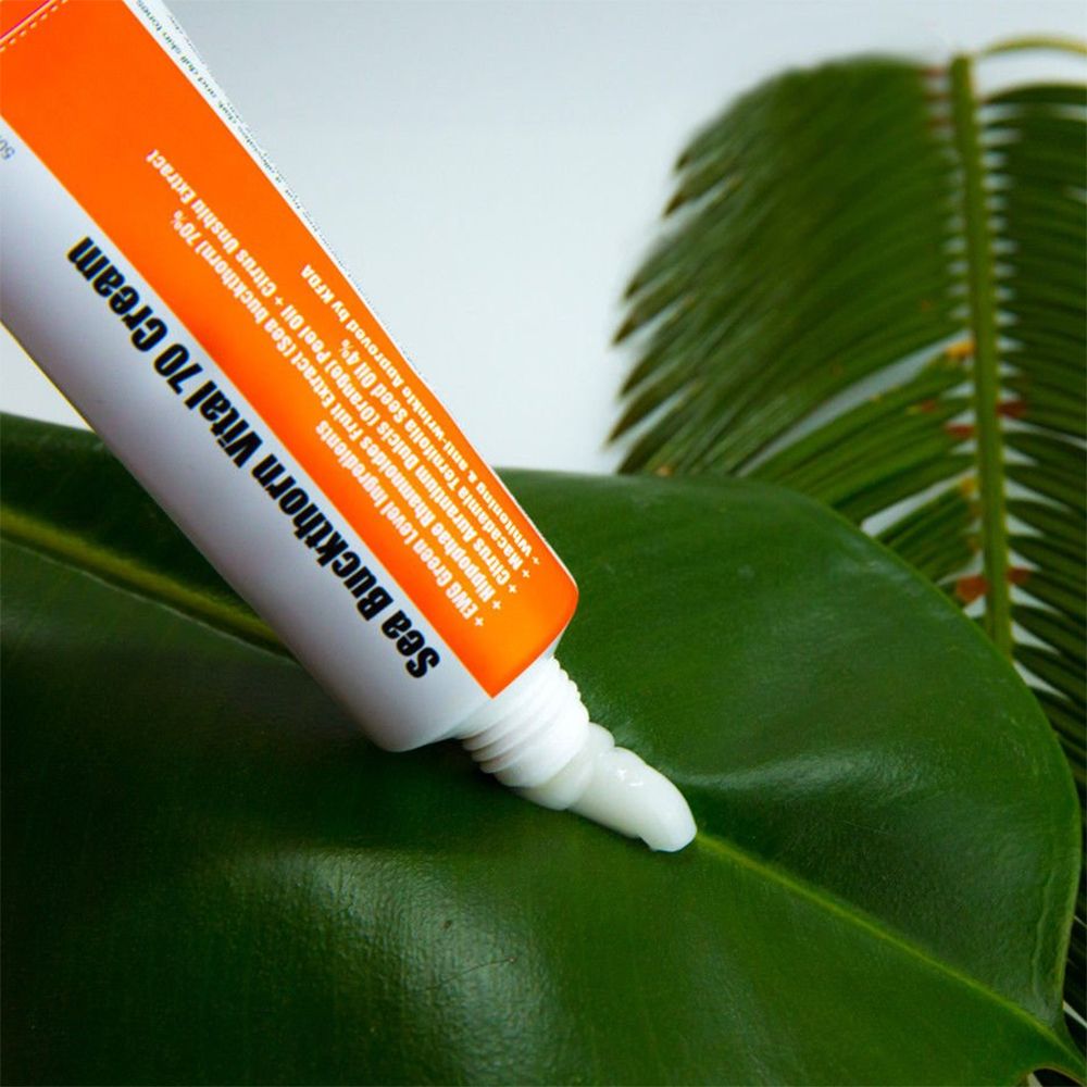 Tubo di crema con nome del prodotto. Design arancione e bianco. Crema su foglia verde. Testo: Sea Buckthorn Vital 70 Cream.