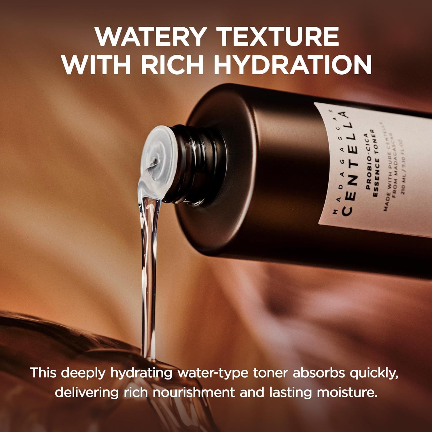 Flacone marrone con tappo bianco. Liquido che esce dall'apertura. Scritta: MADAGASCAR CENTELLA PROBIO-CICA ESSENCE TONER.