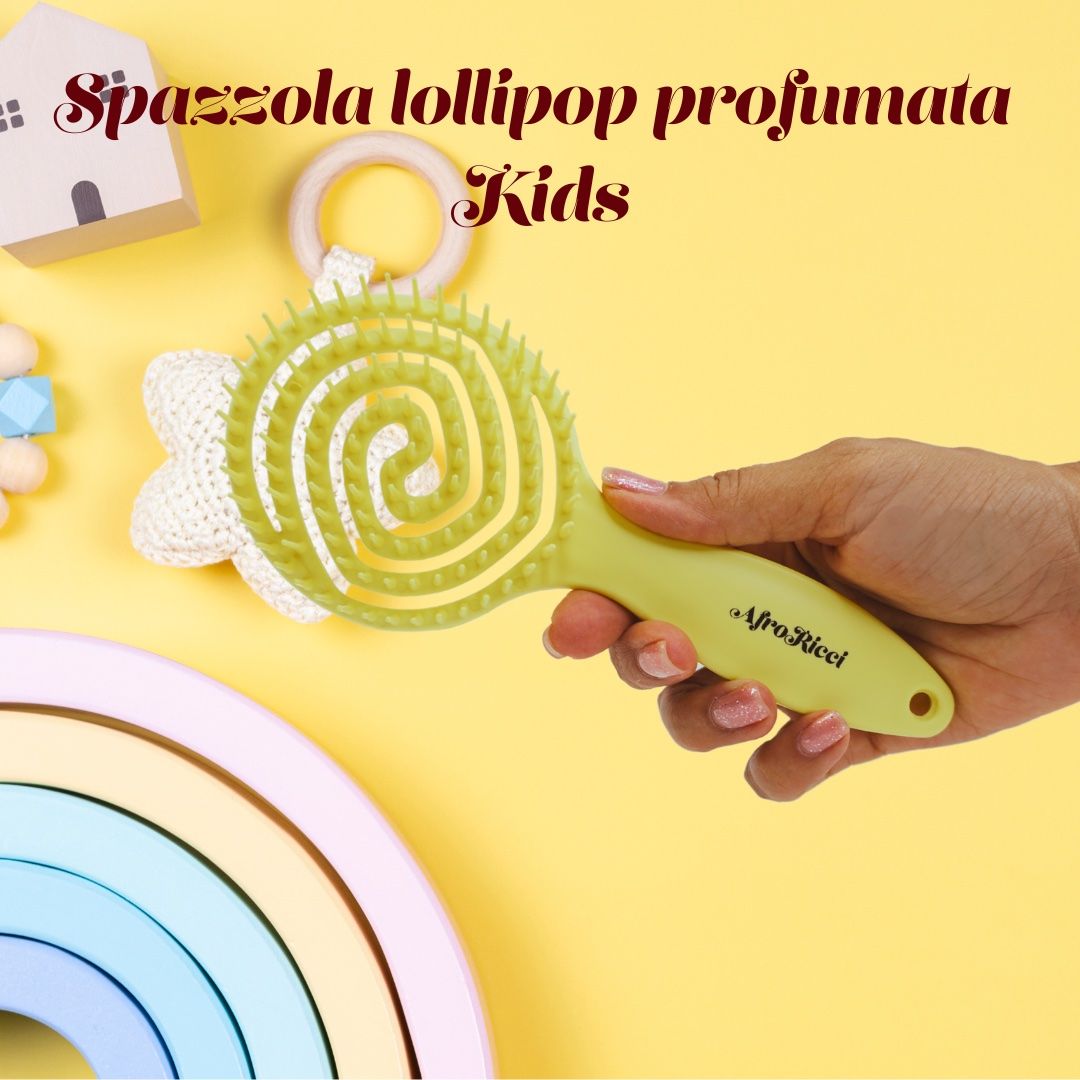 Spazzola gialla tenuta in mano. Accanto a giocattoli. Manico con logo.