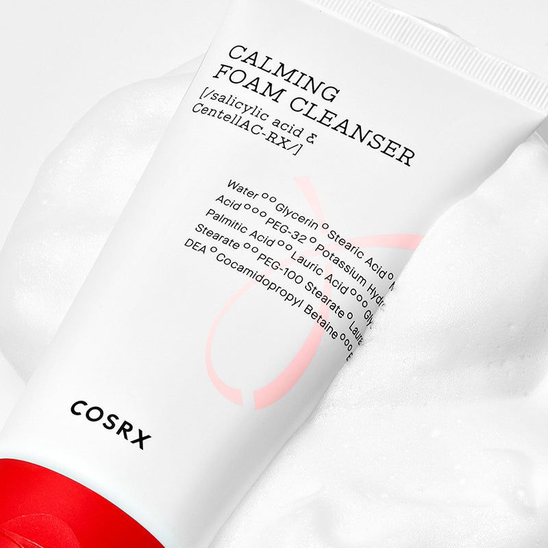 Tubo bianco con tappo rosso nella schiuma. Scritta: Calming Foam Cleanser, ingredienti. Marchio: COSRX.