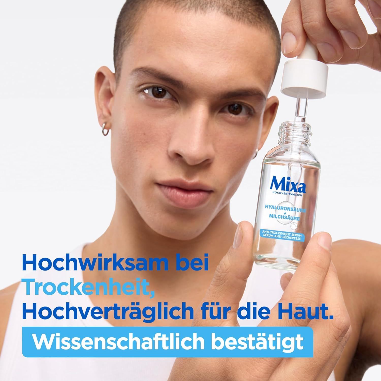 Flacone di siero con pipetta. Scritta Mixa, Acido Ialuronico, Acido Lattico. Uomo che tiene il flacone.
