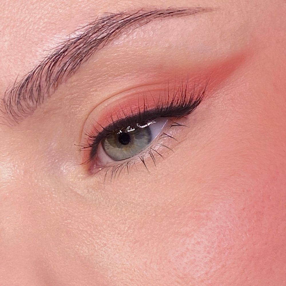 Primo piano di un occhio con ombretto e mascara. Tono della pelle chiaro. Sopracciglio visibile.