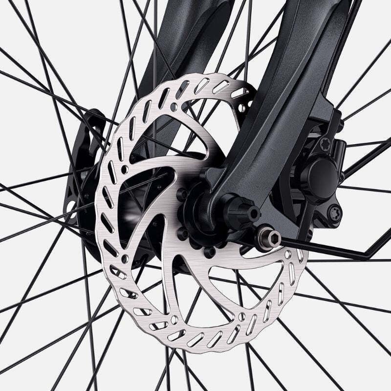 Primo piano del freno anteriore di una e-bike. Il disco del freno è argentato e presenta un motivo forato.