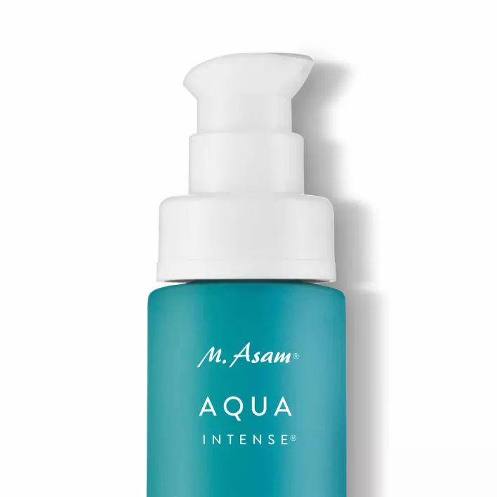 Primo piano della parte superiore del flacone. Testina bianca a pompa su flacone turchese. Scritta: M. Asam AQUA INTENSE.
