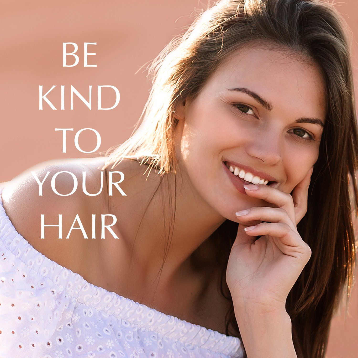 Ritratto di una donna sorridente con lunghi capelli castani. Testo: BE KIND TO YOUR HAIR.