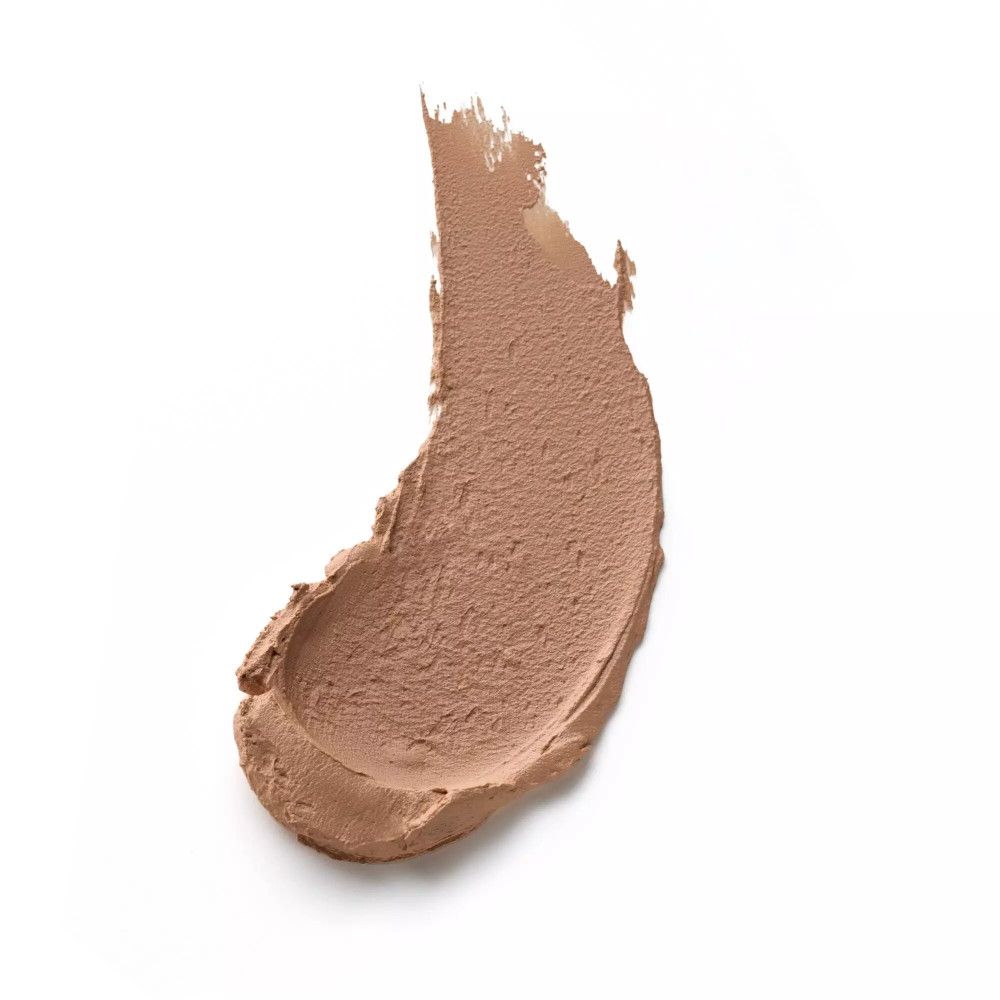 Una striscia di fondotinta marrone su sfondo bianco. La consistenza è simile a una mousse.