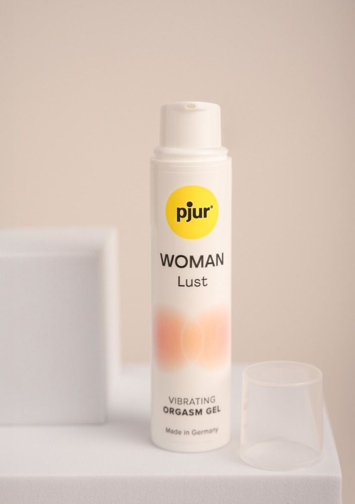 Flacone bianco con logo giallo e scritta: pjur, WOMAN Lust, Vibrating Orgasm Gel. Tappo trasparente accanto.