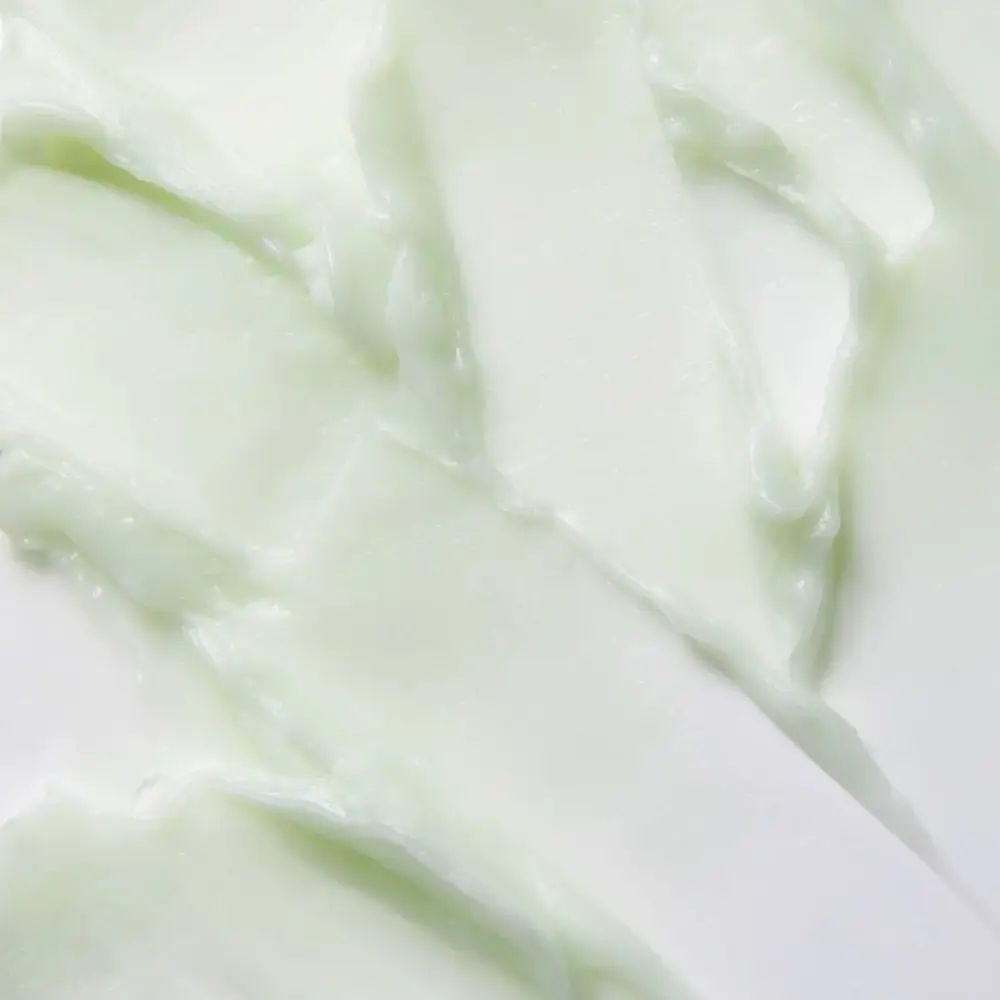 Primo piano della massa del prodotto bianco-verde. Texture con striature visibili. Massa del prodotto su sfondo chiaro.