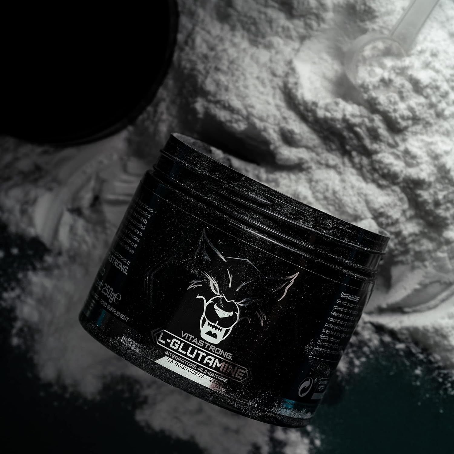 Barattolo nero con polvere bianca e cucchiaio. Scritta: Vitastrong L-Glutammina. Logo lupo.