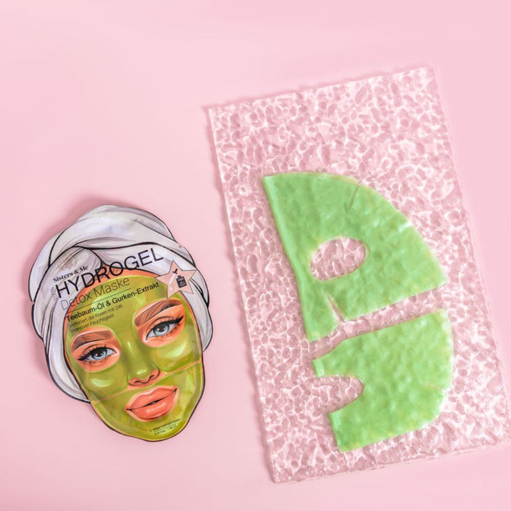 Maschera per il viso e parti di maschera verde su sfondo rosa. Prodotto Sisters & Me.