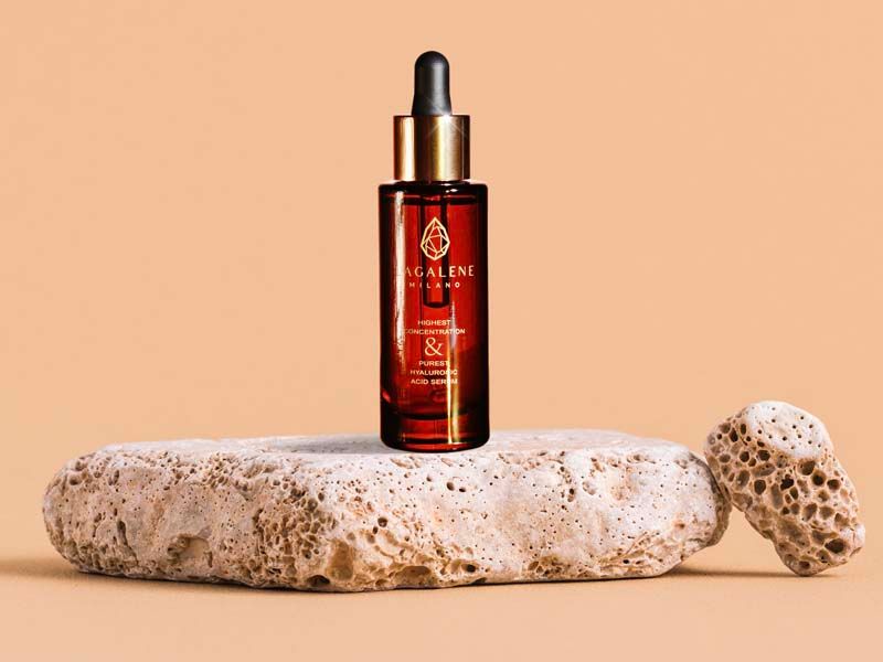 Flacone di siero marrone con tappo dorato. Posizionato su una pietra. Scritta: Lagalene Milano.
