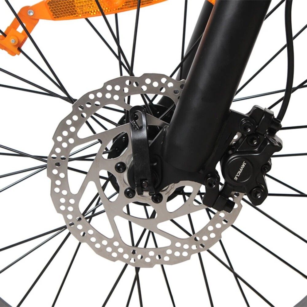 Primo piano del freno a disco. Disco argentato, componenti neri.