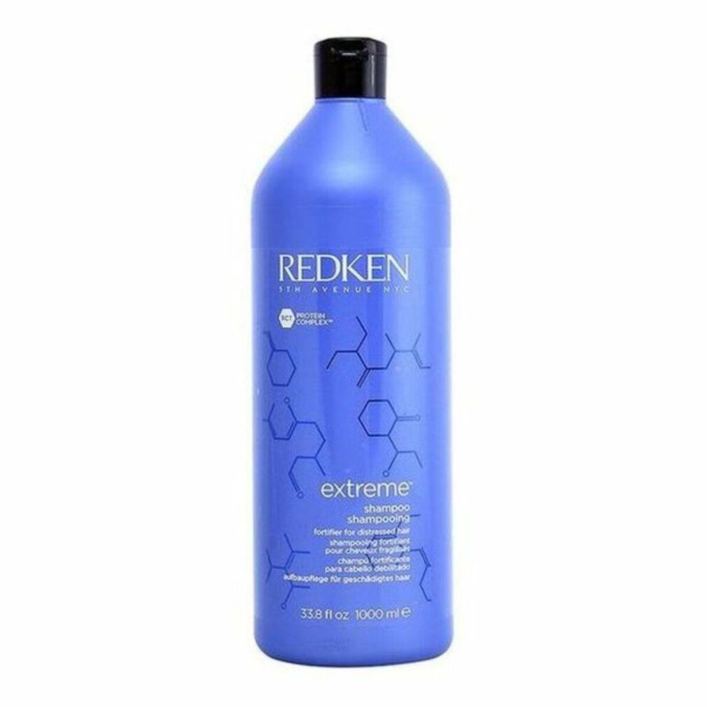 Grande flacone di shampoo blu con tappo nero. Scritta: Redken Extreme Shampoo. Per capelli danneggiati.