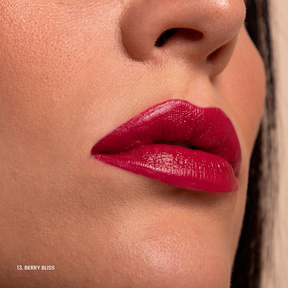 Primo piano di labbra truccate con rossetto rosso lucido. Testo: 13. Berry Bliss.