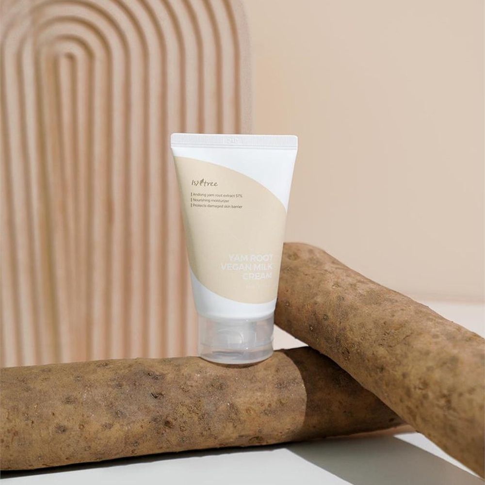 Tubo di crema con nome del prodotto e patate dolci. Sfondo con decorazione ad arco.