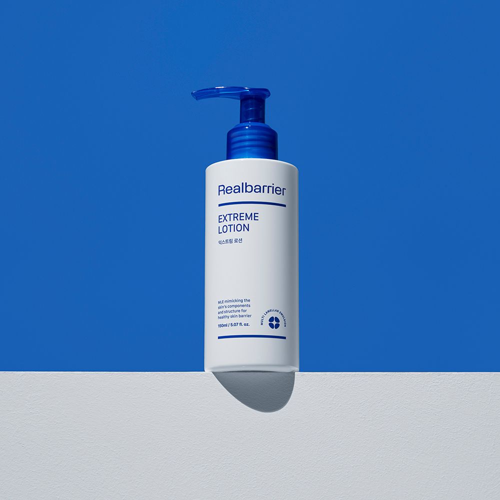 Flacone bianco con erogatore blu. Scritta: Realbarrier Extreme Lotion. Su sfondo blu e bianco.
