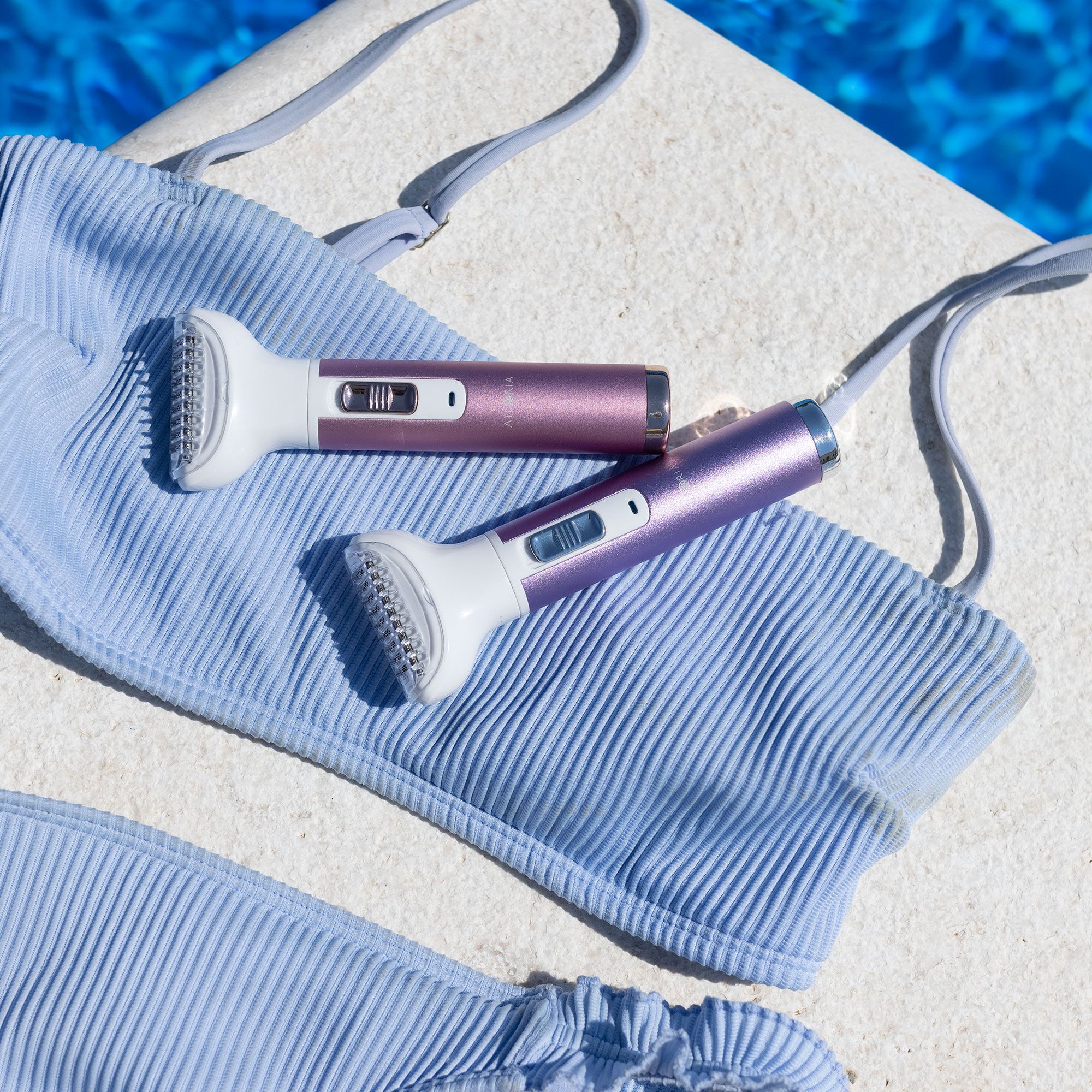 Due rasoi per il corpo su un bikini azzurro. Viola e rosa.