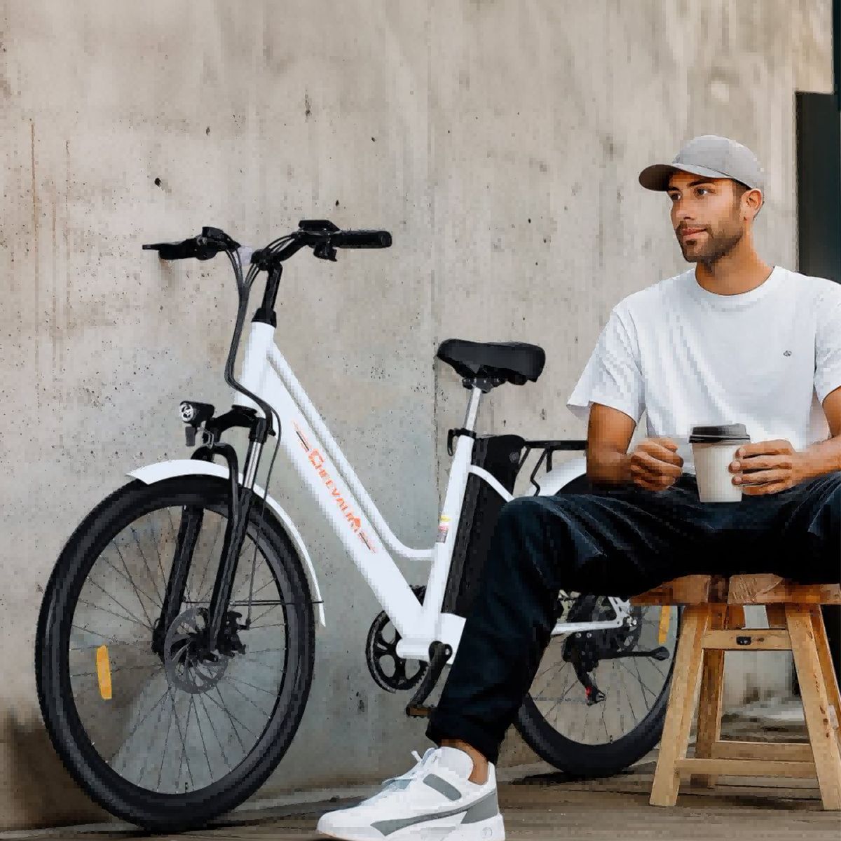 Uomo seduto accanto a una bicicletta elettrica bianca. Marchio Cheevalry.